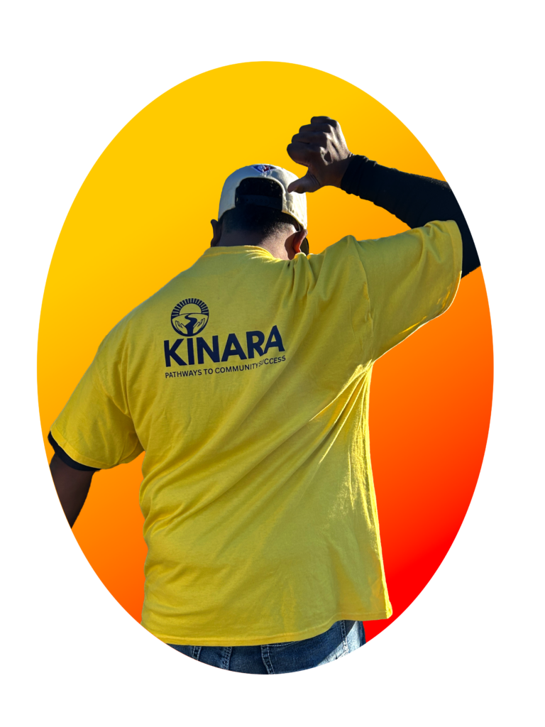 Man wearing a Kinara shirt pointing to his back